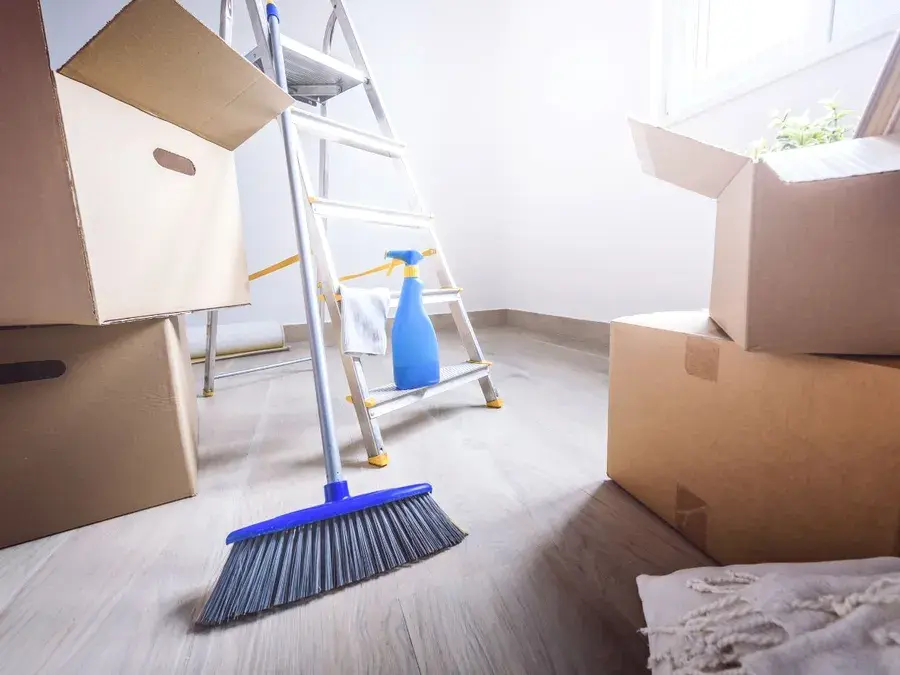 Moving boxes and a broom in an empty room ready for move-out cleaning in Winter Garden, FL