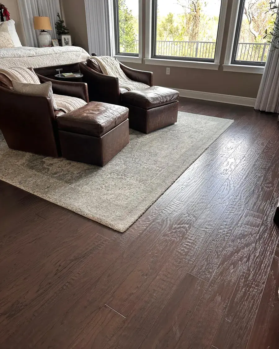 Sitting area with leather armchairs, a rug, and polished wood floors after a biweekly house cleaning in Ferndale, FL