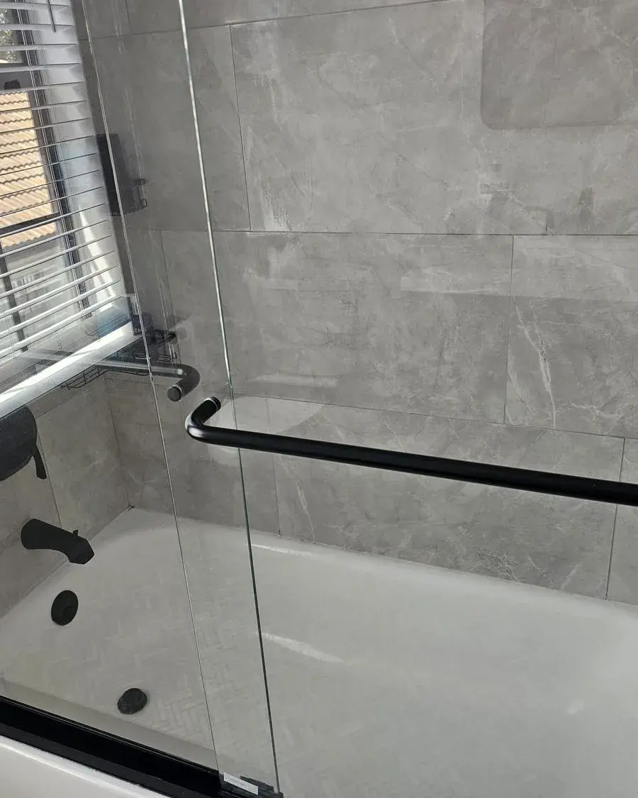 Shower and tub combination with a clean glass door after a biweekly house cleaning in Ferndale, FL