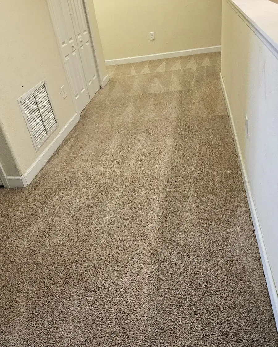 Vacuumed carpet and a dusted wall vent in an empty home after a move-in cleaning in Ferndale, FL