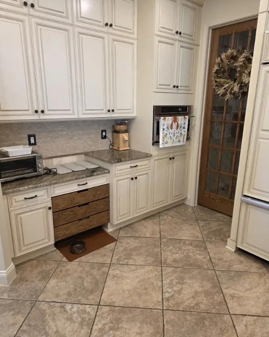 Kitchen with tile floors and cream cabinets after a weekly house cleaning in Ferndale, FL