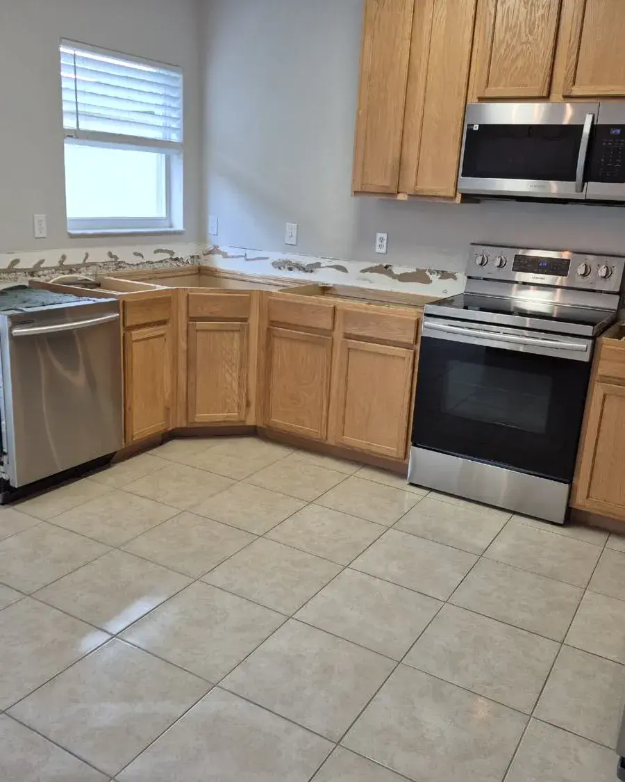 Empty kitchen with stainless appliances and clean tile floors after a move-in cleaning in Horizon West, FL