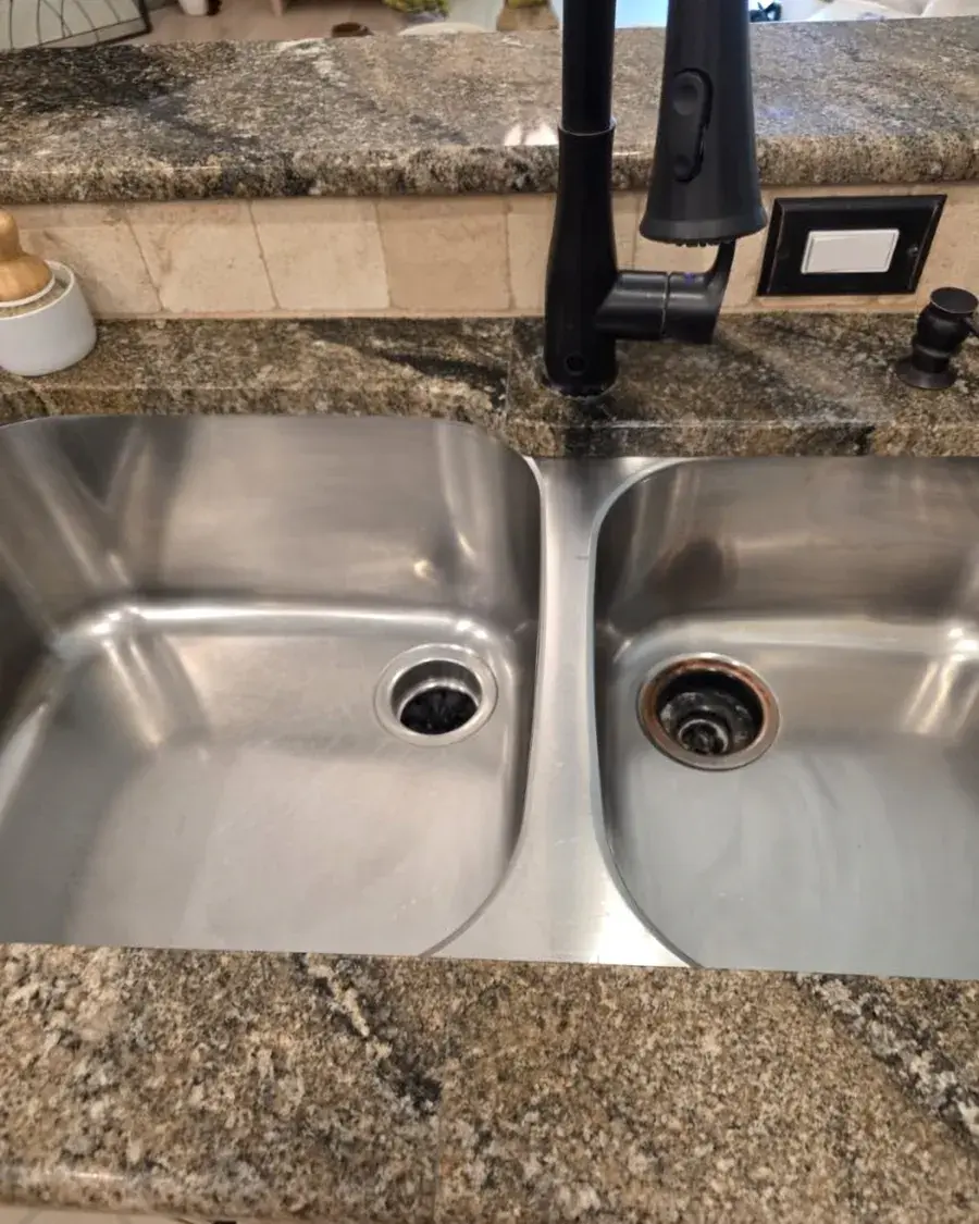 Stainless double kitchen sink scrubbed clean after a biweekly house cleaning in Montverde, FL