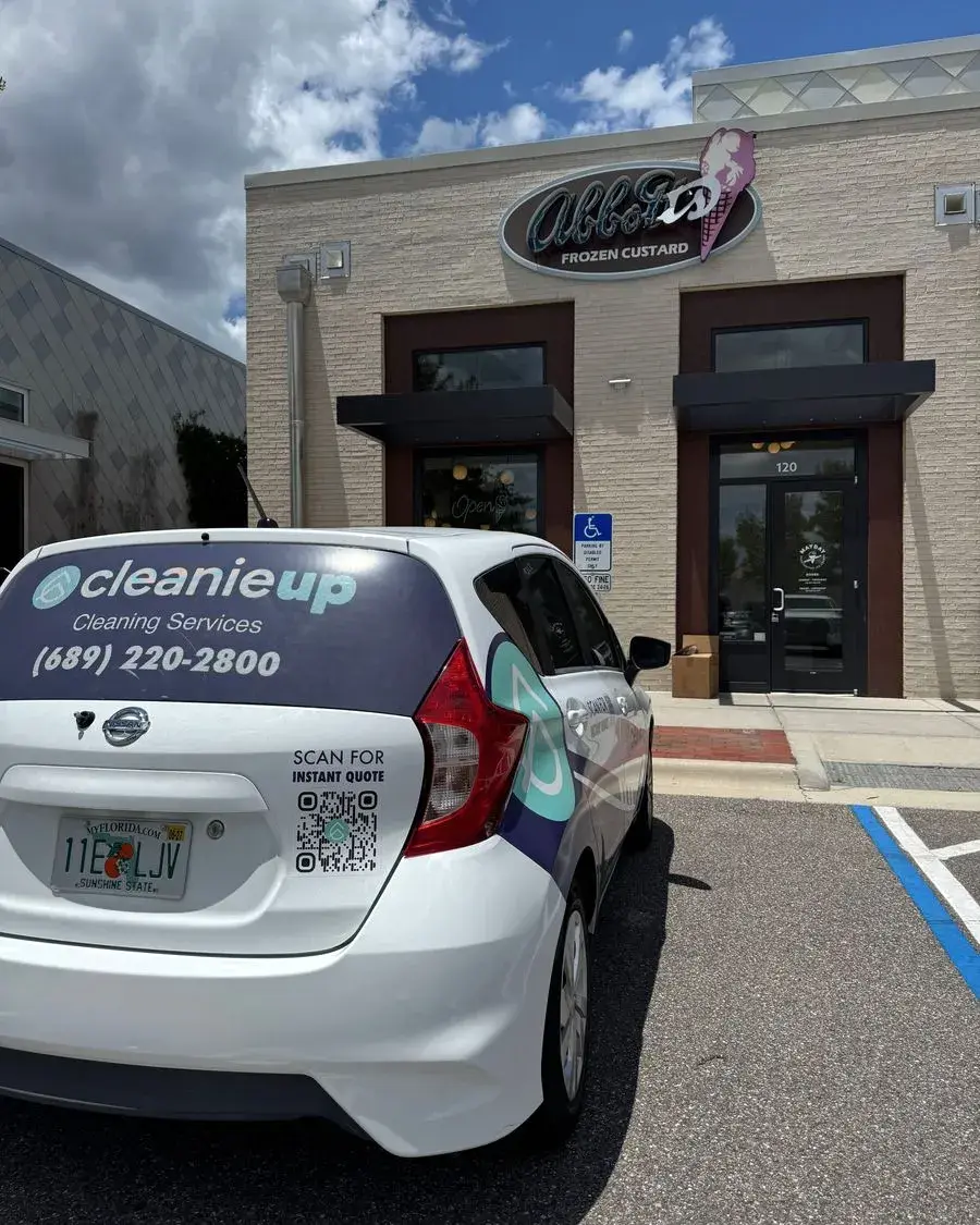 CleanieUp car parked outside a shop entrance for a commercial cleaning in Oakland, FL