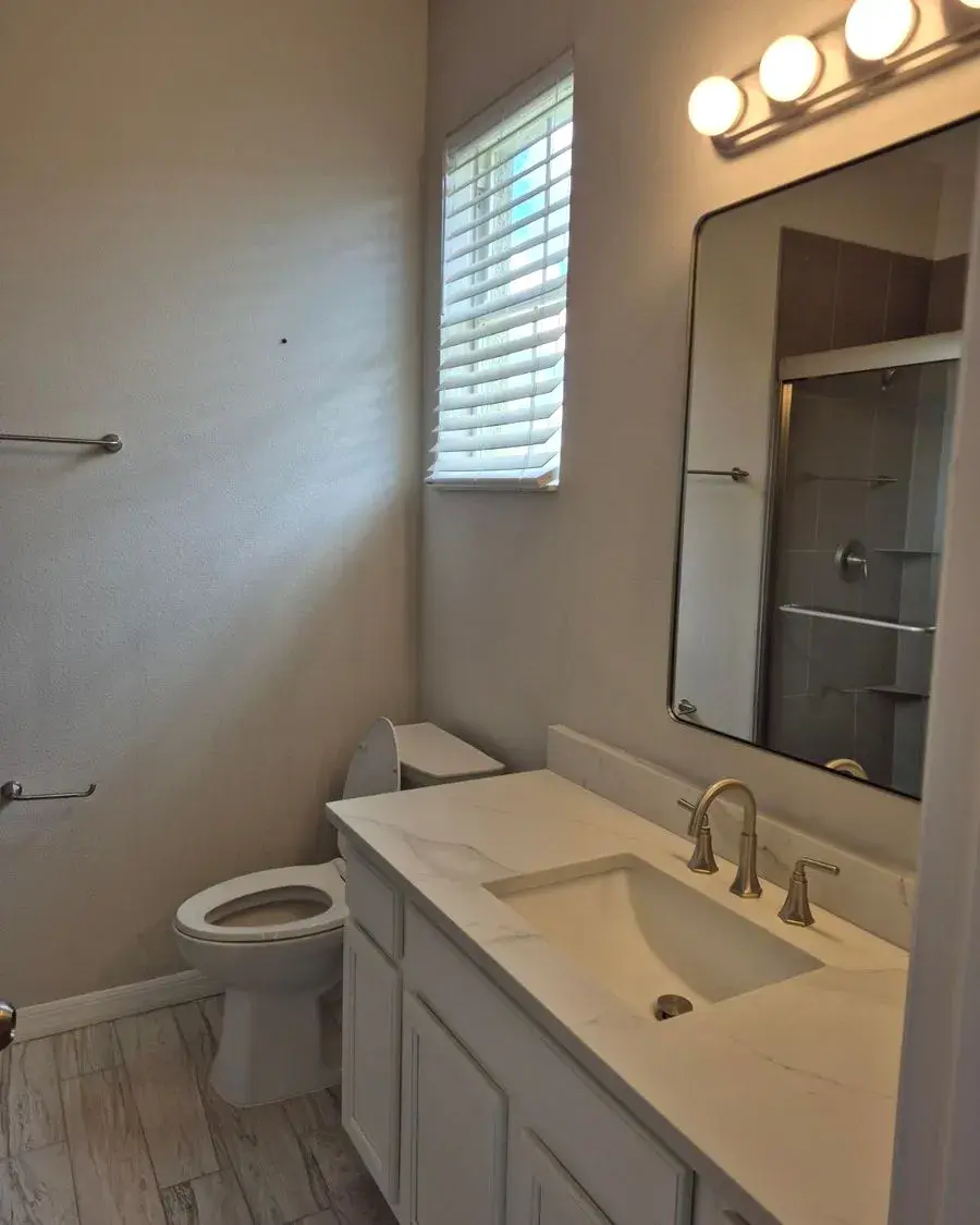 Bathroom with a quartz vanity and polished faucet after a weekly house cleaning in Oakland, FL