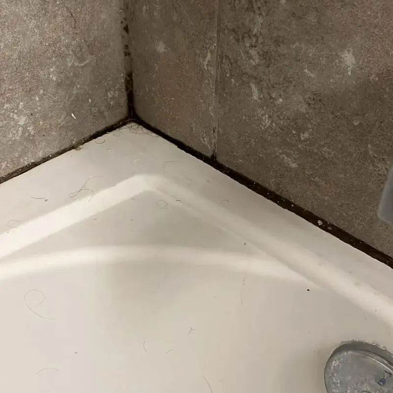 Grime along a bathtub and tile corner before a CleanieUp deep cleaning in Winter Garden, FL