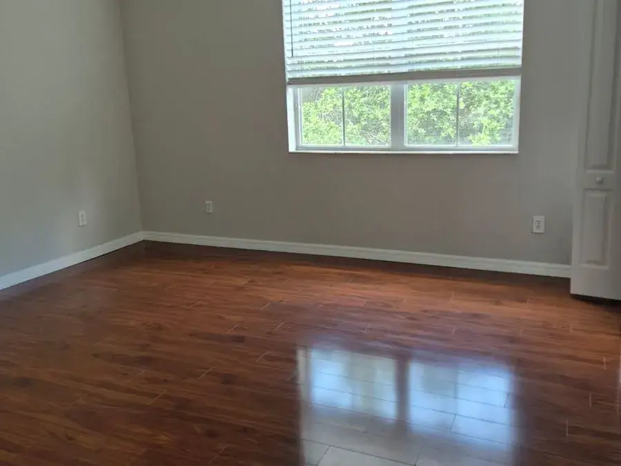 Empty room with gleaming hardwood floors, an example of CleanieUp move-out cleaning in Winter Garden, FL Empty room with gleaming hardwood floors, an example of CleanieUp move-out cleaning in Winter Garden, FL