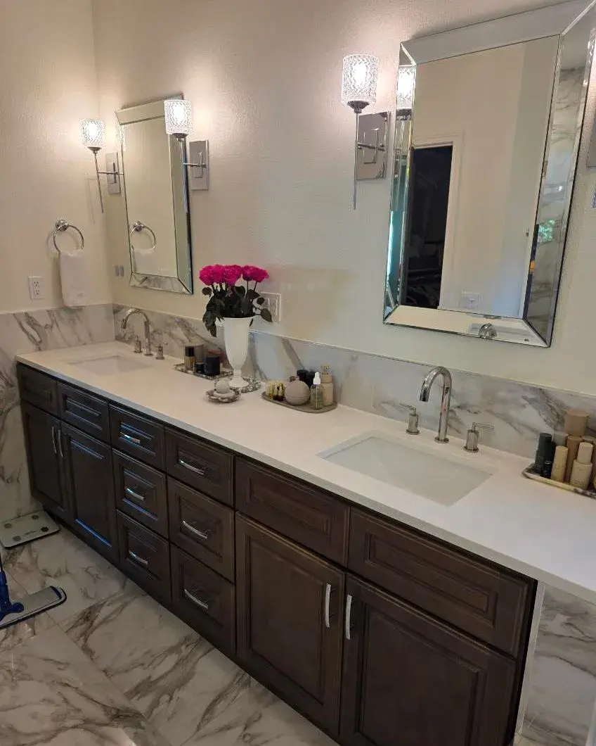 Double bathroom vanity with polished faucets and framed mirrors after a biweekly house cleaning in Horizon West, FL Double bathroom vanity with polished faucets and framed mirrors after a biweekly house cleaning in Horizon West, FL