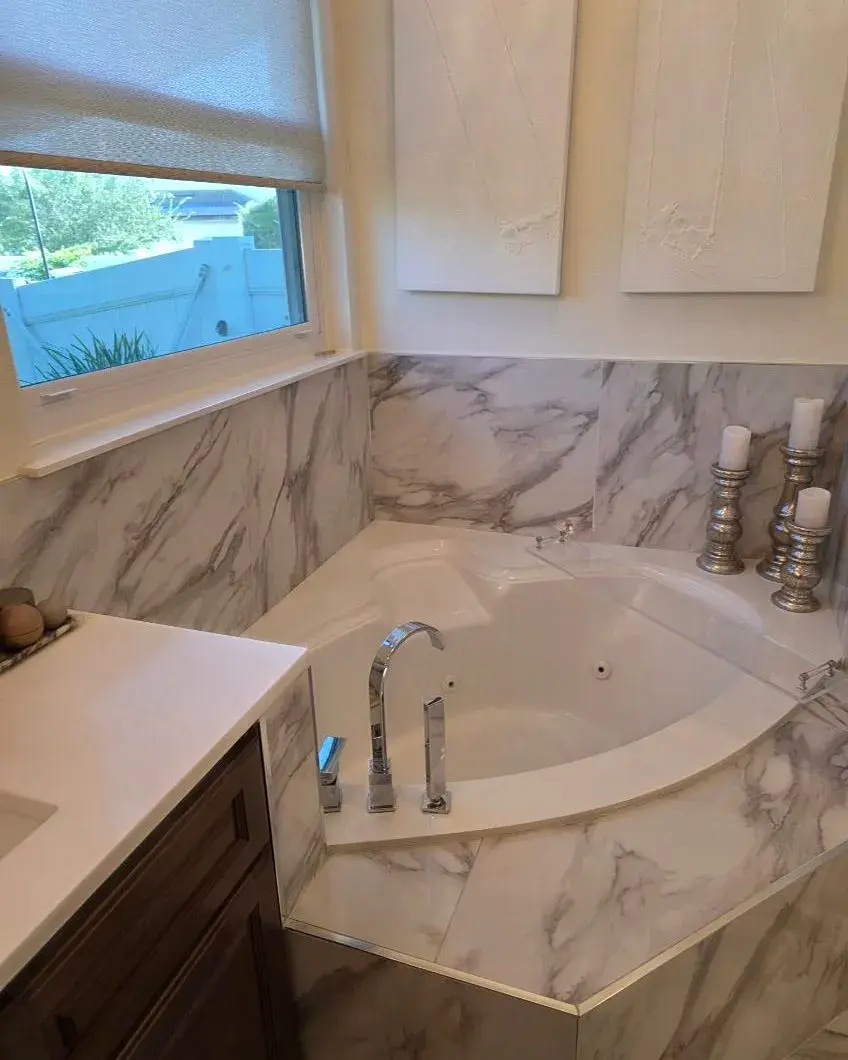 Corner jetted tub with a marble surround and polished fixtures after a weekly house cleaning in Windermere, FL Corner jetted tub with a marble surround and polished fixtures after a weekly house cleaning in Windermere, FL